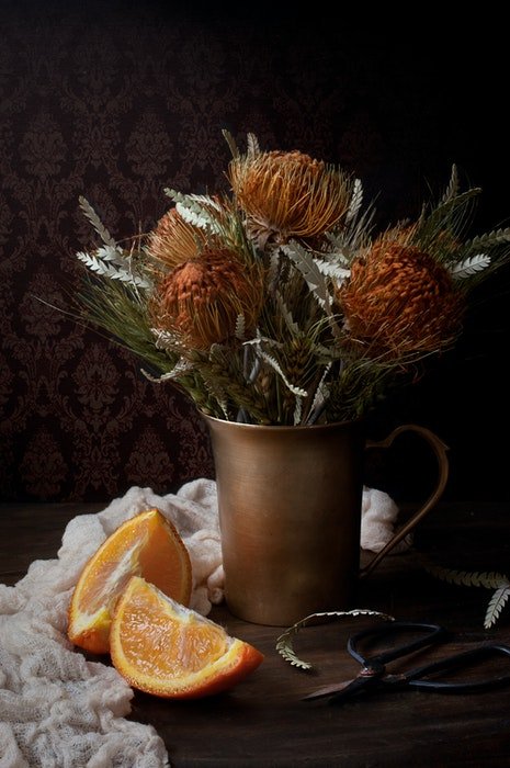 Una fresca composición de naturaleza muerta de un ramo de flores en un jarrón de cobre