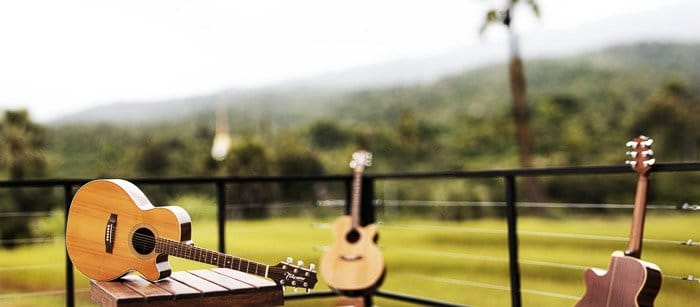 Una guitarra descansando sobre una mesa al aire libre tomada con una lente gran angular