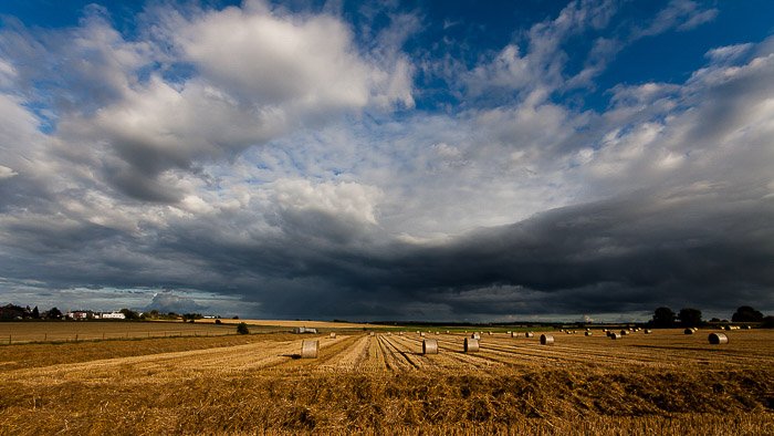 Un paisaje típico de gran angular de un campo bajo un cielo nublado
