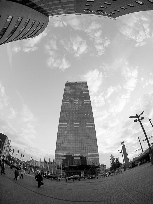 Un rascacielos alto filmado en blanco y negro con una lente de ojo de pez