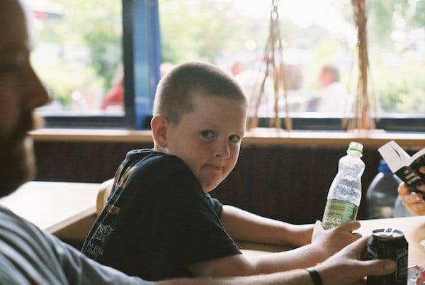 Un niño sosteniendo una botella mira a la cámara - Luz de ventana para retratos