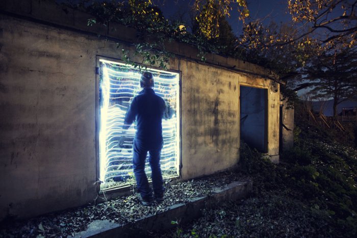 retroiluminación fresca detrás de un hombre explorando un edificio abandonado