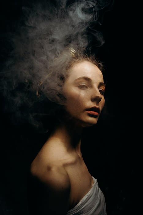 Un retrato temperamental de una niña, con humo usado para crear un efecto dramático