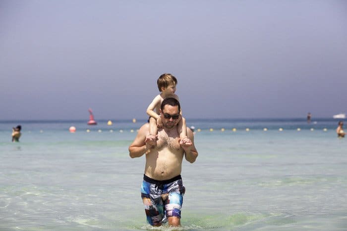 Un padre e hijo caminando en el océano.