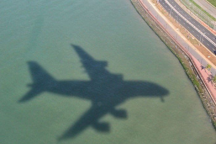 La sombra de un avión en vuelo sobre el agua