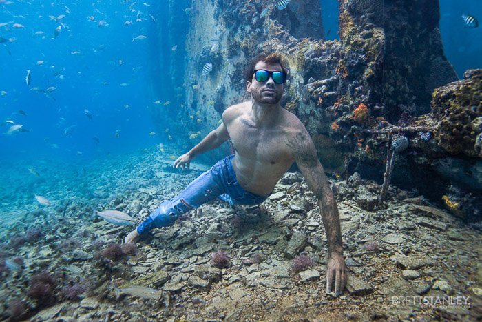 Imagen atmosférica del océano submarino de un modelo masculino nadando bajo el agua