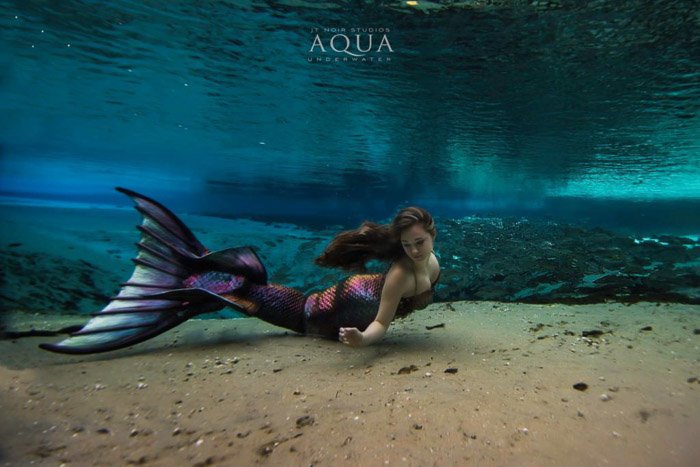 Retrato submarino de ensueño de un modelo femenino con cola de sirena de colores brillantes