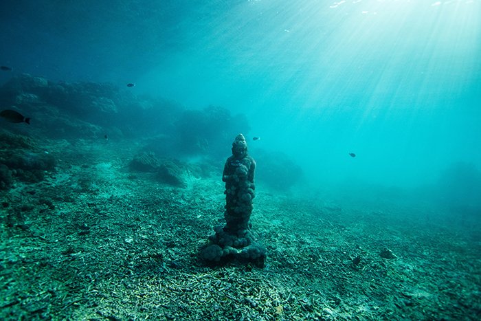 Genial fotografía submarina de una estatua en el fondo del mar