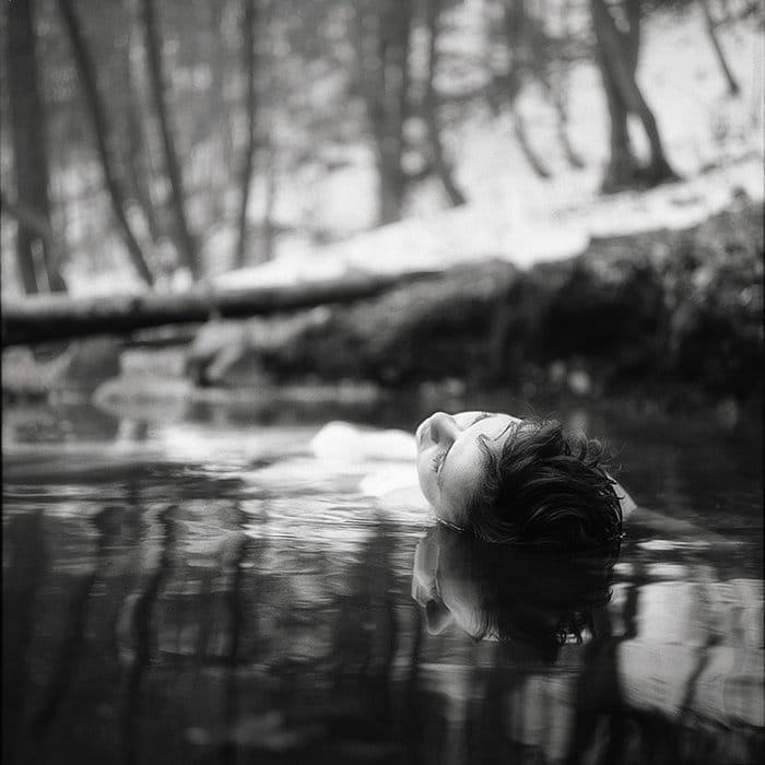 Retrato monótono de una modelo femenina flotando sobre el agua