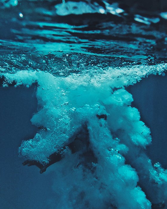 un impresionante retrato submarino de un nadador rodeado de burbujas