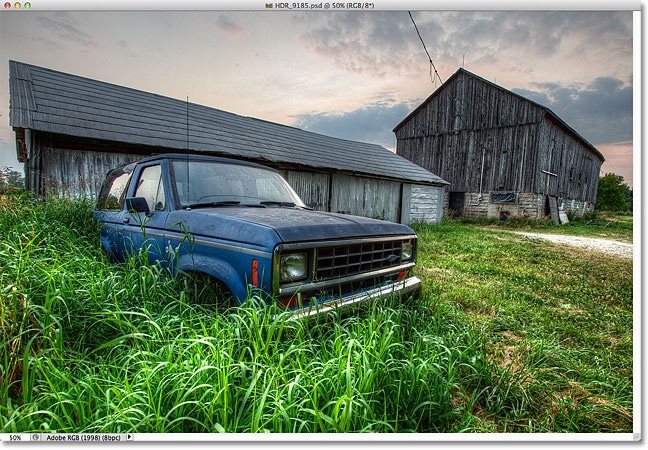 Una foto HDR de un camión viejo en la hierba alta frente a un granero degradado.  Imagen © 2012