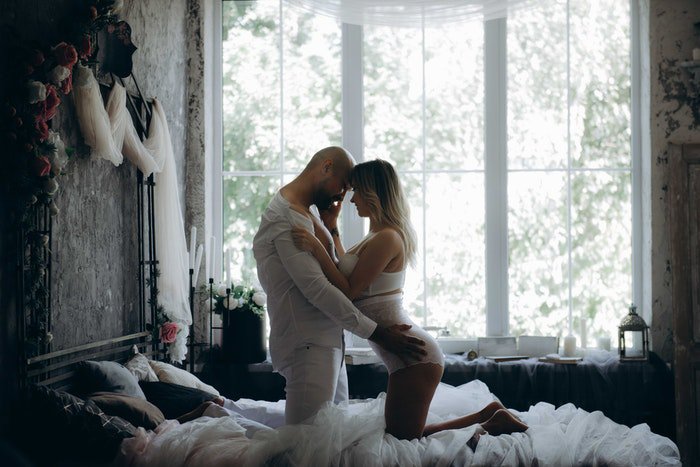Una sexy sesión de fotos de tocador de San Valentín de una pareja en una cama