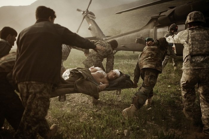 Soldados ayudando a heridos a subir a un helicóptero por Moises Saman