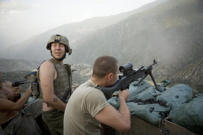 Soldados apuntando armas hacia las montañas, fotografía de guerra por Tim Hetherington