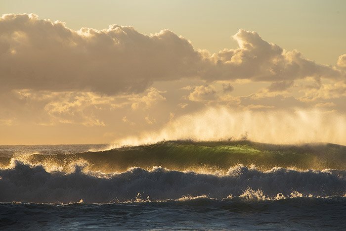 Paisaje marino al amanecer con mar agitado y agua verde y hermosas olas retroiluminadas entrantes: configuración de fotografía de agua