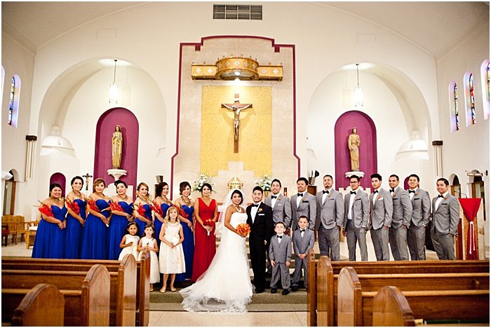 Una foto de grupo de una fiesta de bodas posando en una iglesia - fotografía con flash de boda
