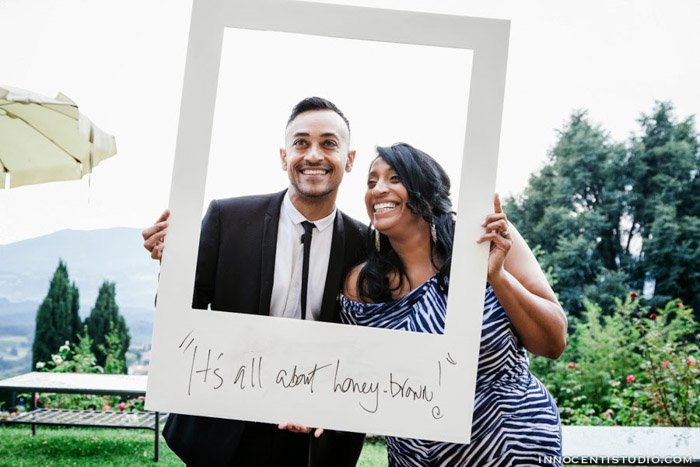 una imagen de una pareja de novios que usa un marco Polaroid grande como fotomatón