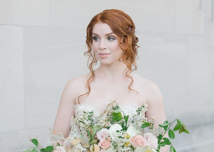 foto de una novia pelirroja contra un fondo completamente blanco, sosteniendo un gran ramo de flores: los mejores consejos de edición de fotos de bodas