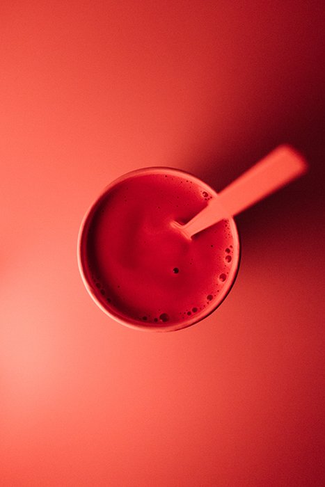 Fotografía cenital de una bebida roja sobre fondo rojizo, utilizando colores vibrantes en la fotografía