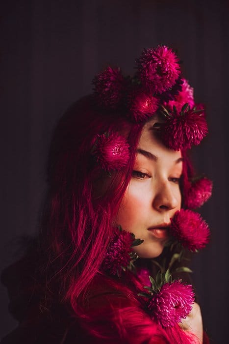 Foto de retrato de una mujer con flores rosas en el pelo