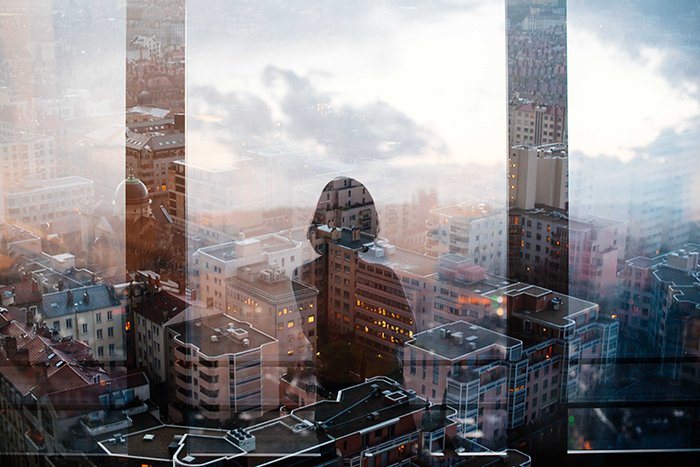 Foto de la silueta de una mujer reflejada en la ventana de un rascacielos