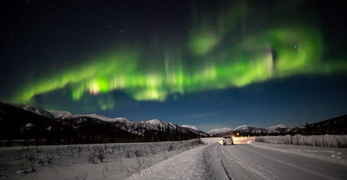 La Aurora sobre un asentamiento en los campos nevados de Alaska