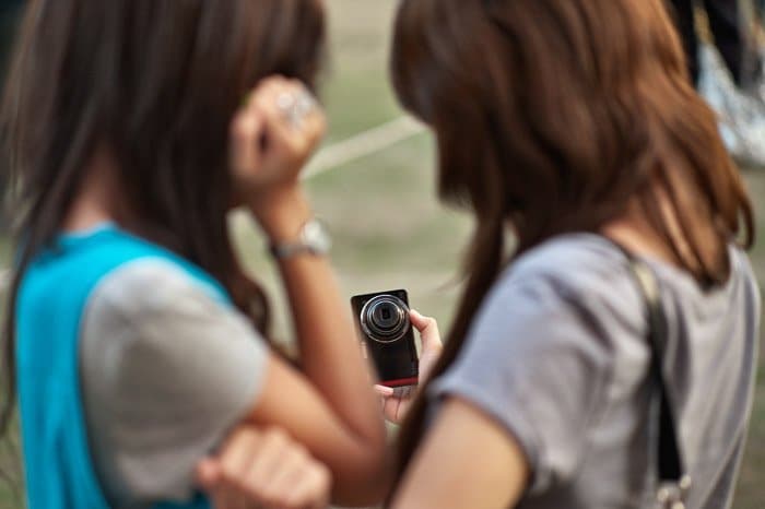Dos chicas tomando un selfie con una cámara: profundidad de campo superficial vs profunda