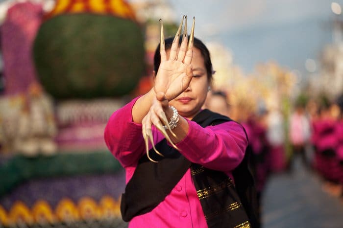 Una foto de una mujer tailandesa bailando en un desfile callejero