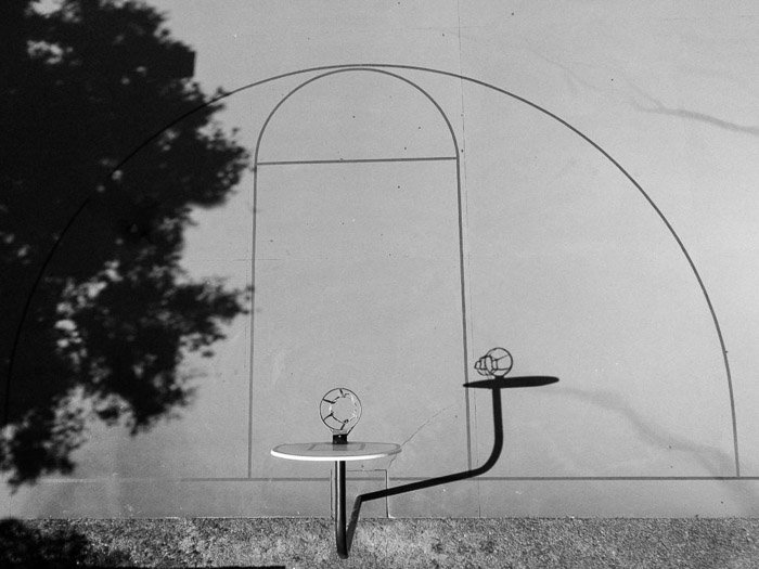 Fotografía en blanco y negro de la sombra de una estructura proyectada en una pared: consejos para la fotografía de sombras