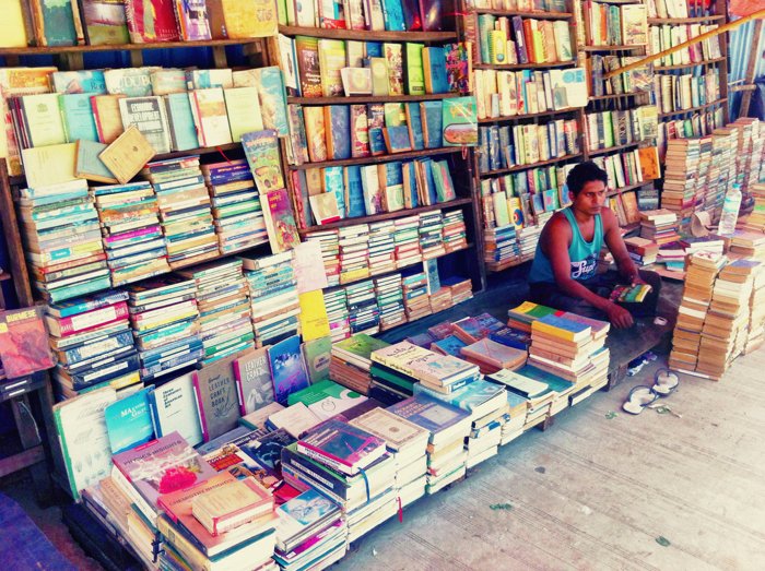 Una fotografía callejera de un smartphone de un vendedor cuidando su puesto de libros