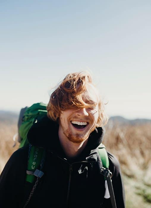 Un excursionista masculino sonriente: cómo sonreír para las fotografías