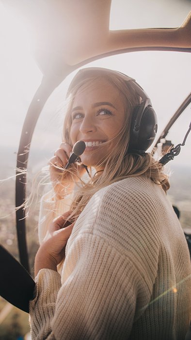 Una alegre foto de una mujer rubia en un avión sonriendo naturalmente