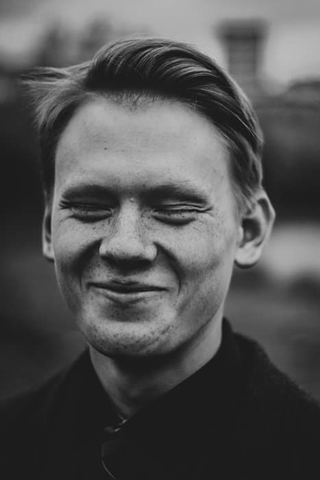 Un retrato en blanco y negro de un hombre sonriendo de forma natural: cómo sonreír para las fotografías