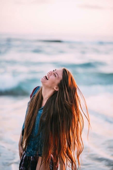 Divertido retrato de una modelo femenina riendo lanzando su cabello castaño rojizo - como sonreír para fotos