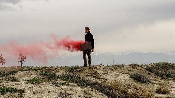 Retrato atmosférico de una mujer sosteniendo granadas de humo rojo
