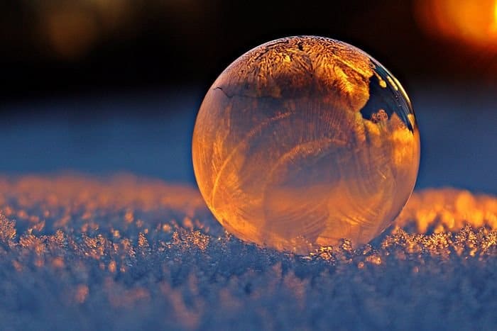 Foto de primer plano de una burbuja de jabón que refleja los copos de nieve