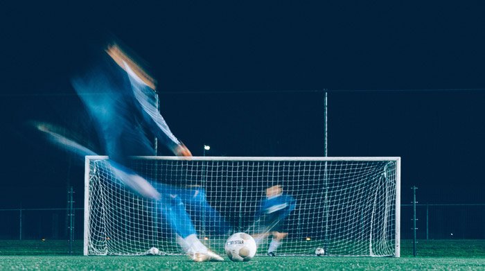 Fotografía de fútbol artístico de un jugador borroso en el campo por la noche