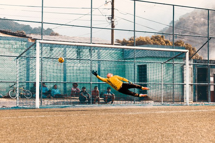 Una fotografía de fútbol de un portero que intenta salvar un gol.