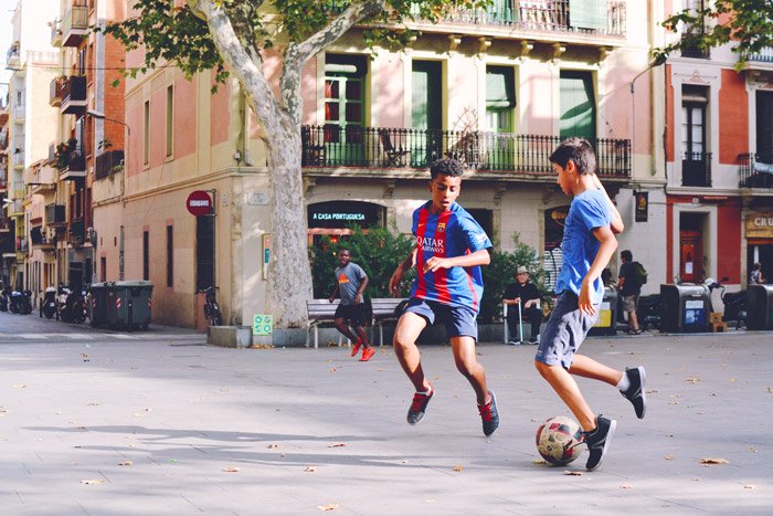 Una foto de fútbol de dos niños jugando al fútbol en la calle.