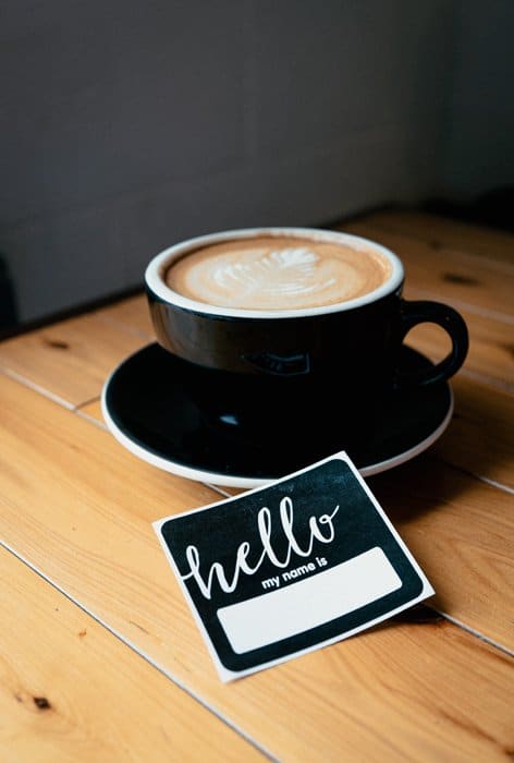 Una taza de café junto a una placa de identificación
