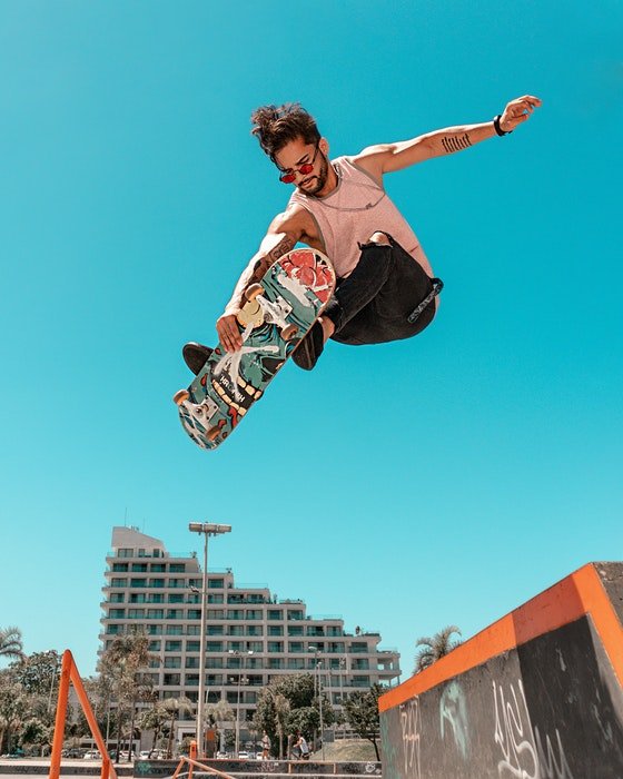 Foto de un skater saltando contra el cielo azul