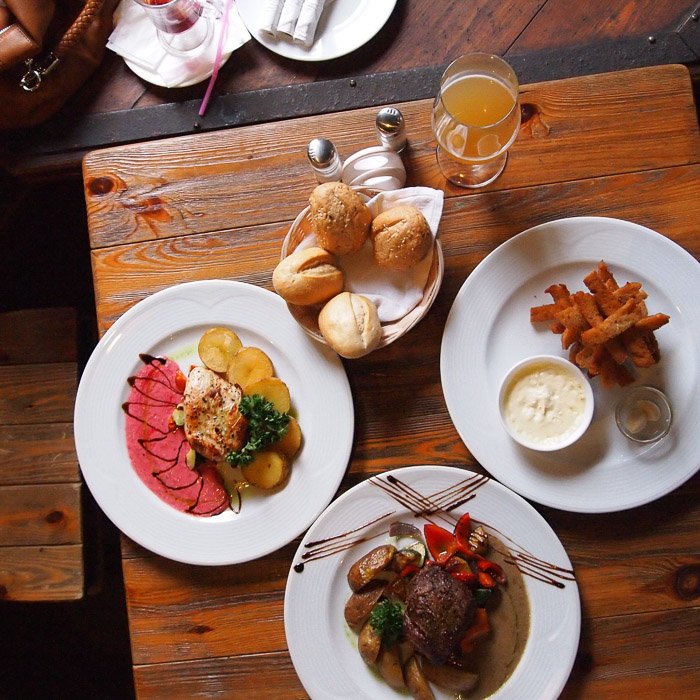 Fotografía aérea de alimentos toma de un almuerzo de aspecto lucious servido en una mesa de madera rústica