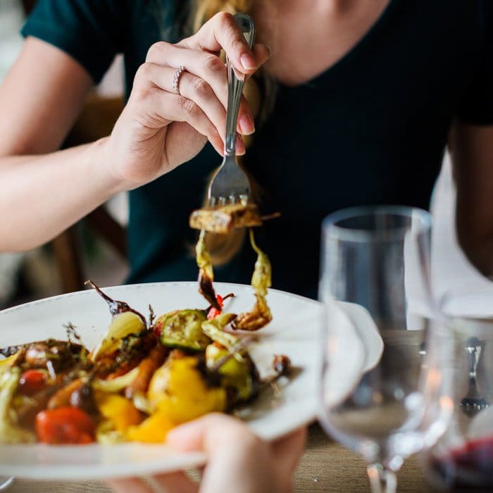 Una fotografía de alimentos de un teléfono inteligente de cerca de personas que comparten un delicioso brunch en una mesa