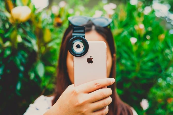 Foto de una niña sosteniendo su iPhone frente a su cara para tomar una foto