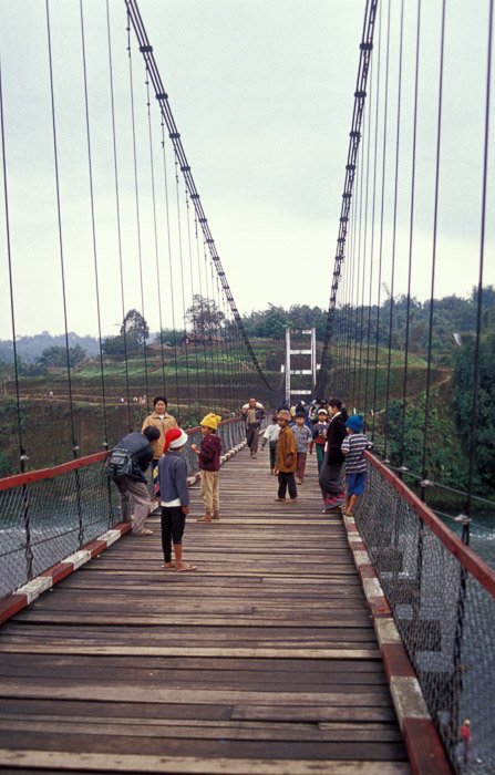 Un grupo de personas cruzando un puente de madera.