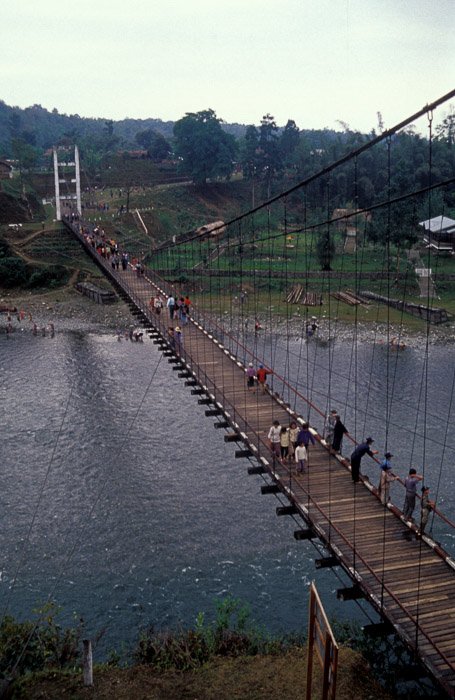Vista aérea de un grupo de personas cruzando un puente de madera