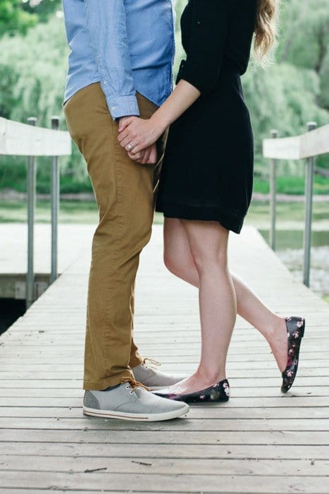 Una foto recortada de una pareja abrazándose en una pose relajada natural en un escenario al aire libre