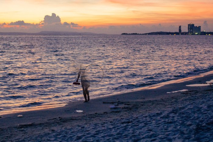 Captura de pantalla que muestra cómo eliminar personas de las fotografías utilizando una foto de una mujer caminando por la playa al atardecer