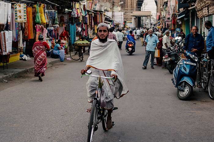 Hombre indio en bicicleta en un mercado de huida: rostro intercambiado en Photoshop