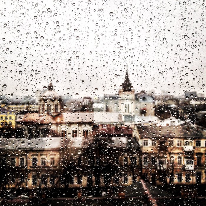 Un paisaje urbano visto a través de una ventana salpicada de lluvia